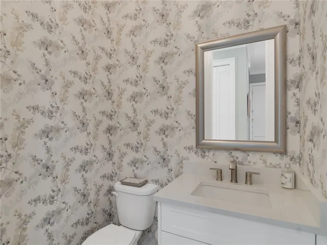 a bathroom with a toilet sink and mirror