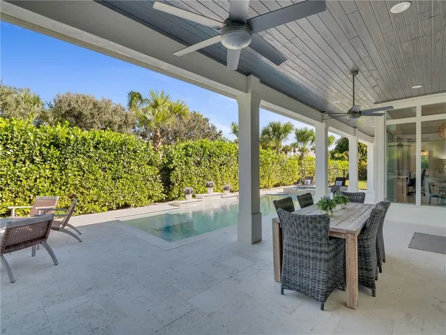 a dining room with furniture and a floor to ceiling window