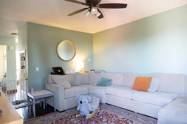 a living room with a couch and a fan