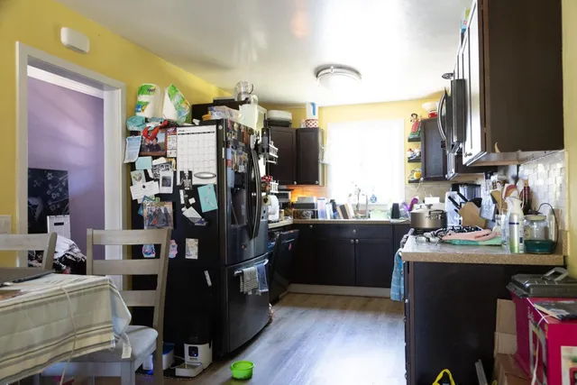 a view of a kitchen with fridge and workspace