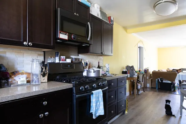 a kitchen with stainless steel appliances granite countertop a stove a sink dishwasher and cabinets with wooden floor