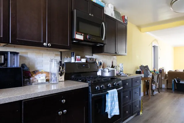 a kitchen with stainless steel appliances granite countertop a stove a sink dishwasher and cabinets with wooden floor