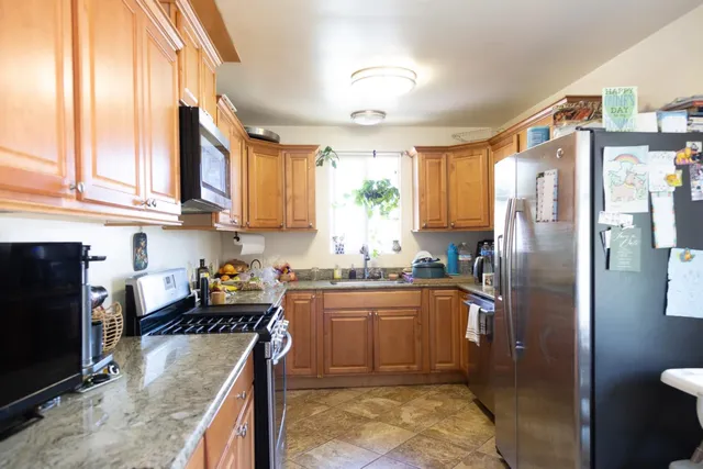 a kitchen with stainless steel appliances granite countertop a refrigerator sink and cabinets
