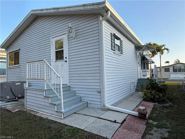 a view of house with a yard and potted plants