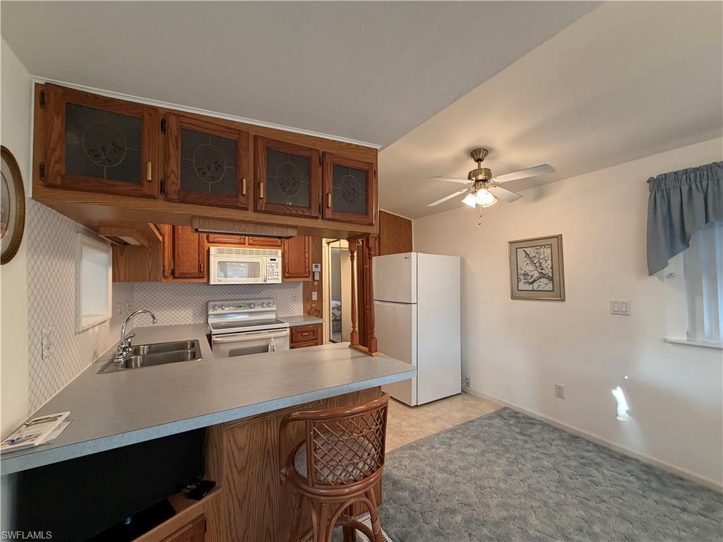 4680 Washington Way West Estero, FL 33928 - Photo 10 of 19 a workspace with kitchen island a stove a refrigerator and cabinets
