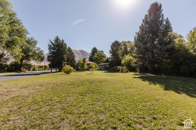 3959 Main Street Logan, UT 84321 - Photo 26 of 35 Expansive green lawn with mature trees and a mountain backdrop
