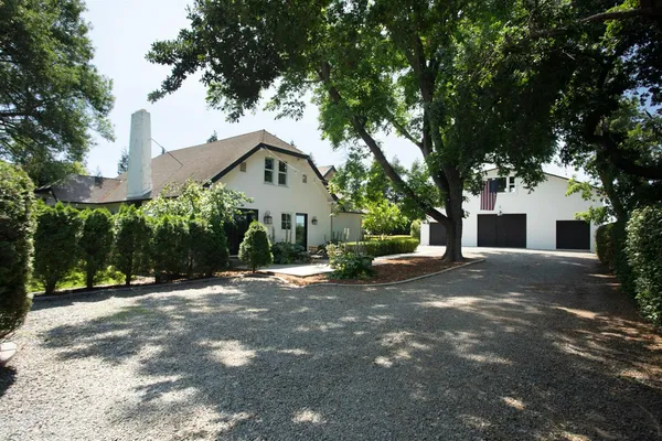 a view of a house with a yard and tree s
