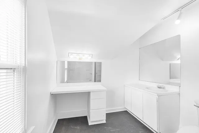 a view of an empty room with cabinet and a window