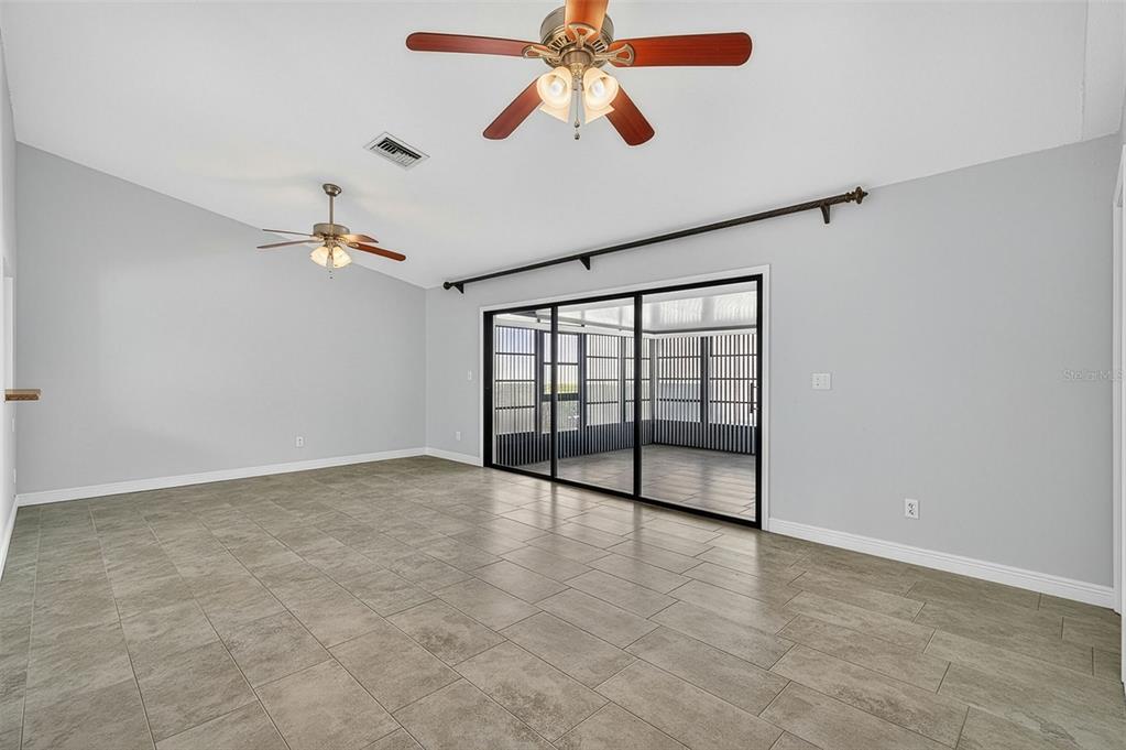 321 Windrush Loop Tarpon Springs, FL 34689 - Photo 14 of 47 an empty room with chandelier fan and windows