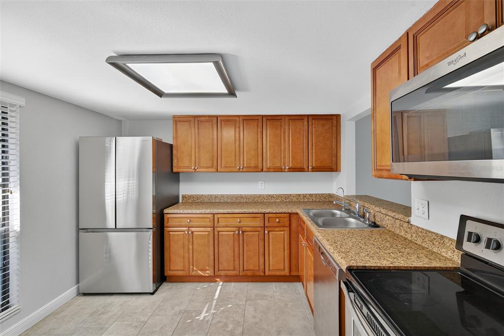 321 Windrush Loop Tarpon Springs, FL 34689 - Photo 2 of 47 a kitchen with a sink a refrigerator and cabinets