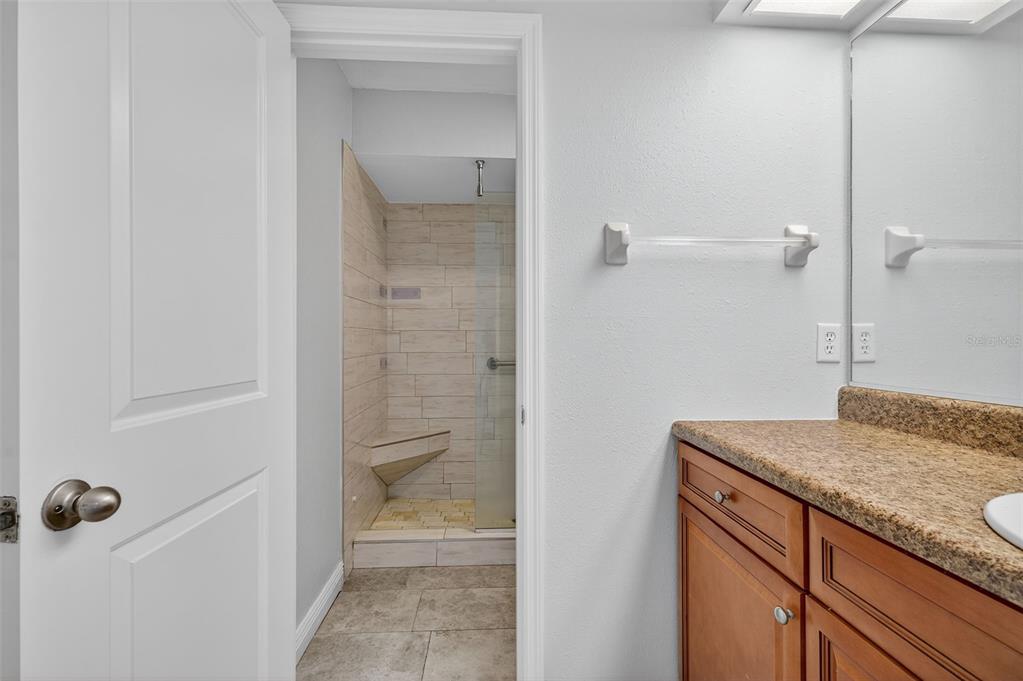 321 Windrush Loop Tarpon Springs, FL 34689 - Photo 22 of 47 a bathroom with a granite countertop sink a mirror and shower
