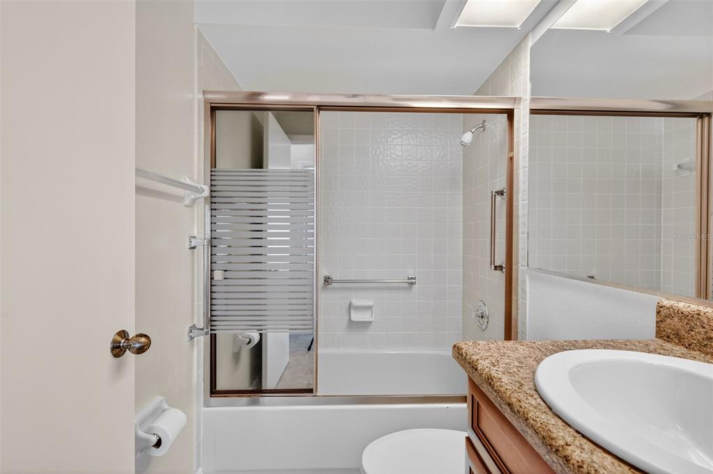 321 Windrush Loop Tarpon Springs, FL 34689 - Photo 28 of 47 a bathroom with a granite countertop bathtub shower sink vanity and toilet