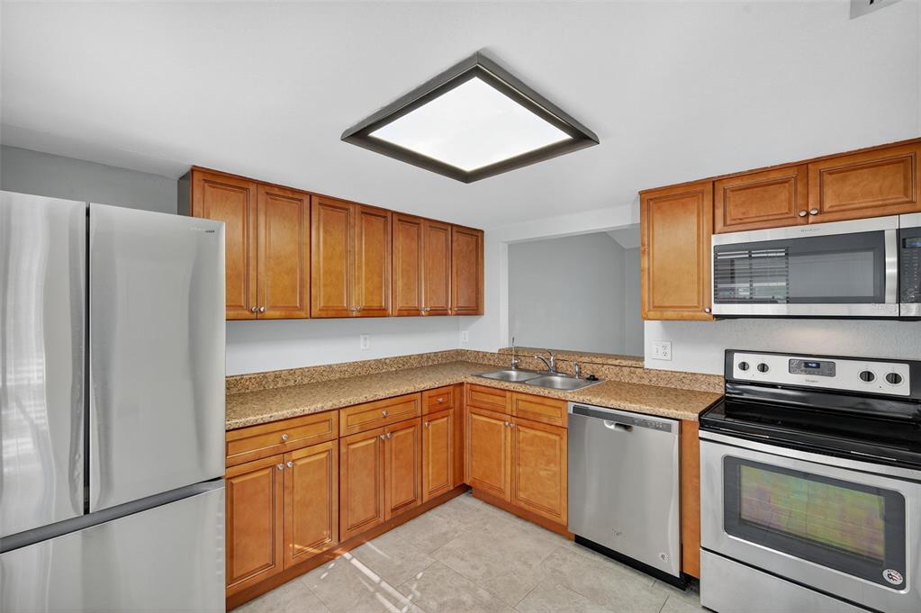 321 Windrush Loop Tarpon Springs, FL 34689 - Photo 9 of 47 a kitchen with a sink stove and refrigerator