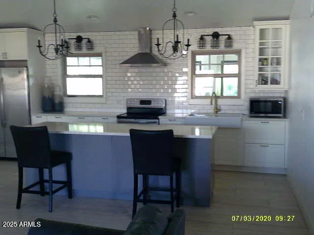 a kitchen with stainless steel appliances granite countertop a sink a stove a table and chairs