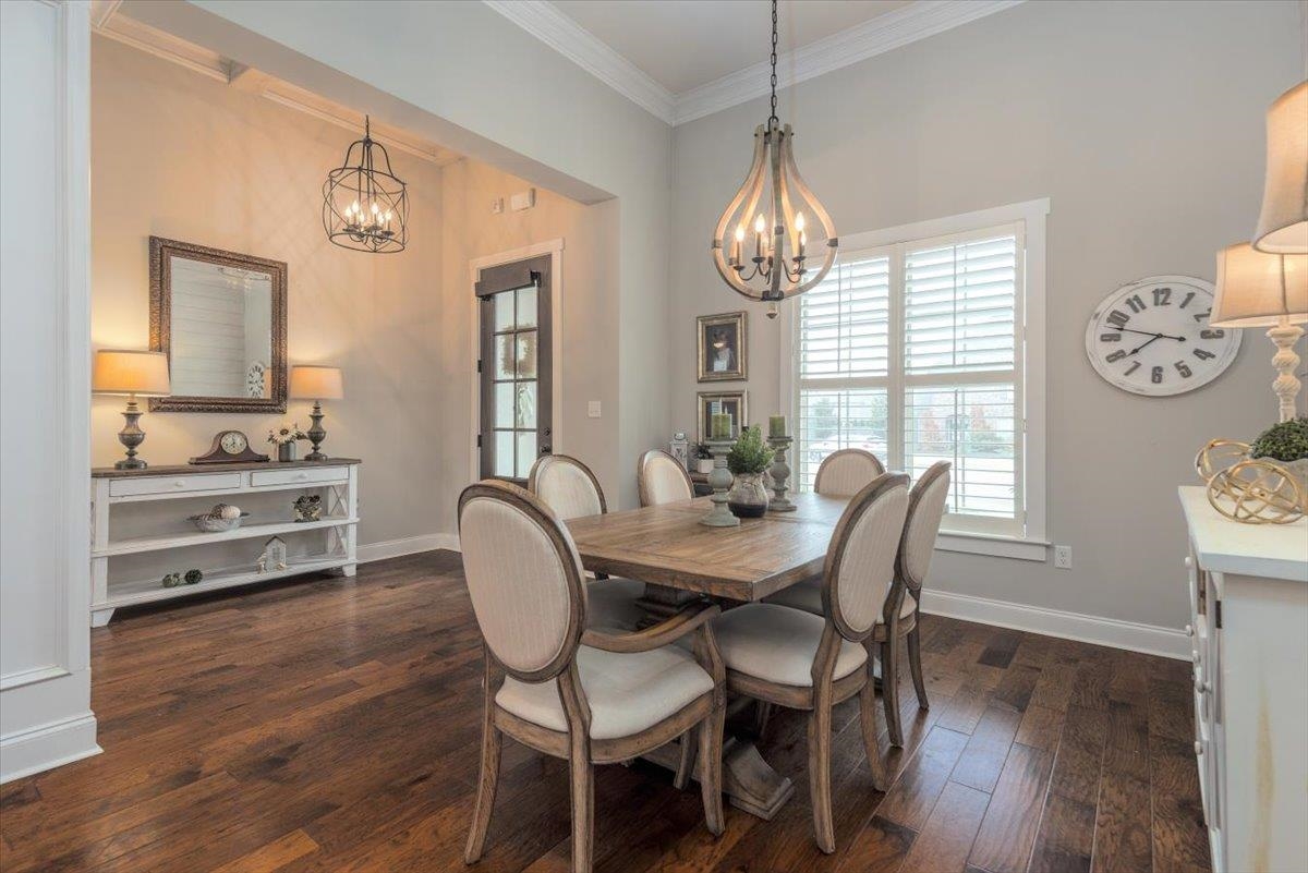 608 Cypress Run Cove Collierville, TN 38017 - Photo 9 of 40 Dining space with dark wood-style floors, crown molding, and a chandelier