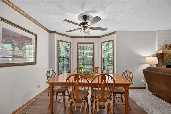 a kitchen with stainless steel appliances a stove a refrigerator a sink a dining table and chairs