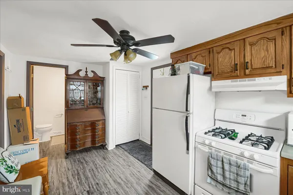 a kitchen with stainless steel appliances granite countertop a refrigerator a stove and a sink with wooden floor