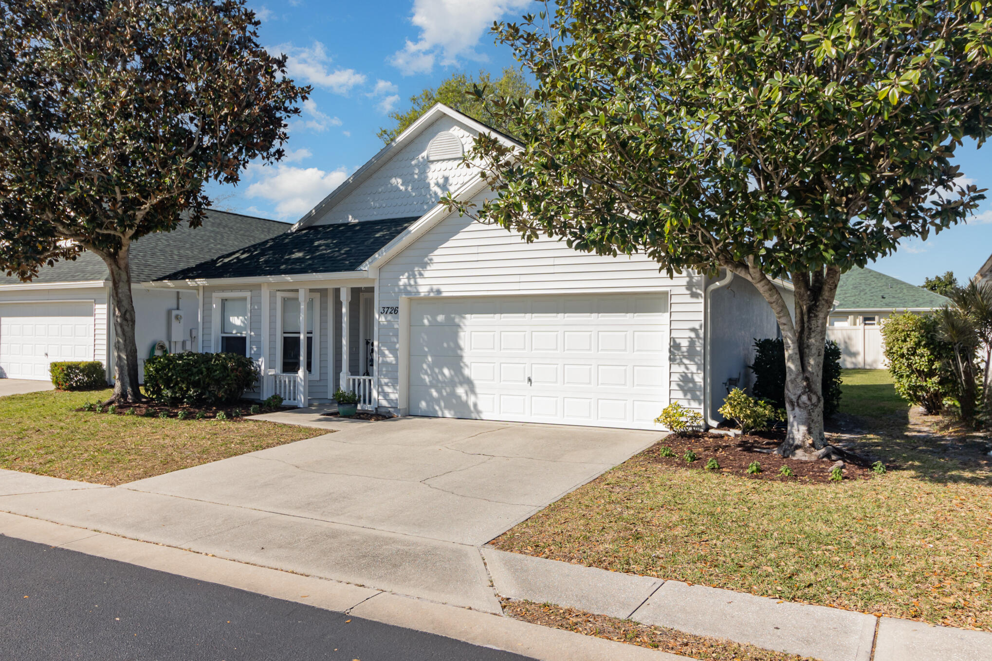 3726 Town Square Boulevard, Unit 84 Melbourne, FL 32901 - Photo 16 of 21 a front view of a house with a yard and garage