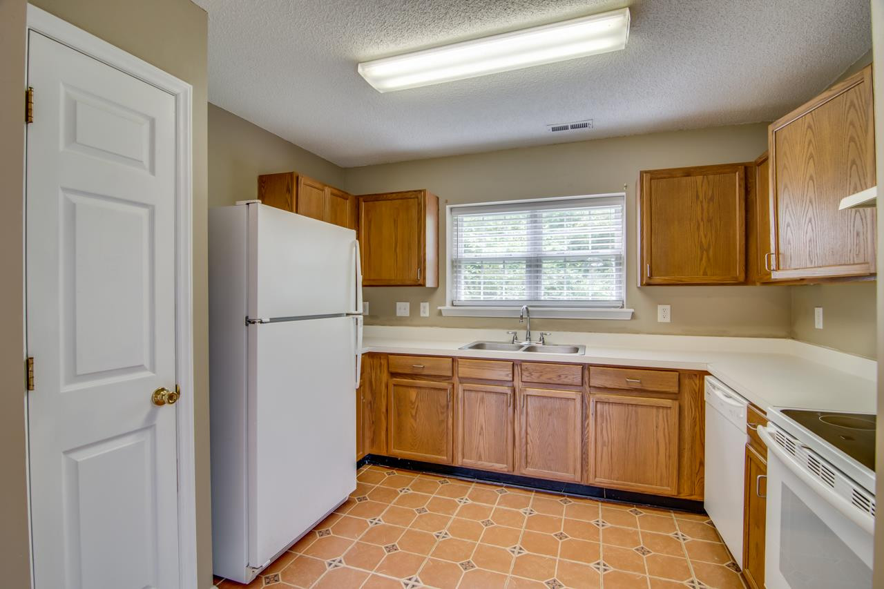 5008 Gable Ridge Drive Durham, NC 27713 - Photo 9 of 20 a kitchen with a sink a refrigerator and cabinets