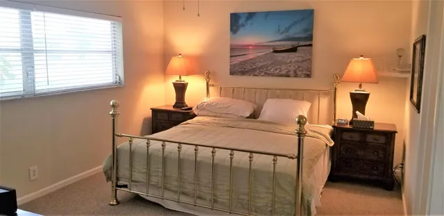 a bedroom with a bed and a painting on the wall