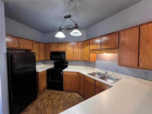 a kitchen with stainless steel appliances granite countertop a sink a stove and refrigerator
