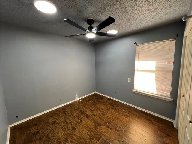 an empty room with a window and a ceiling fan
