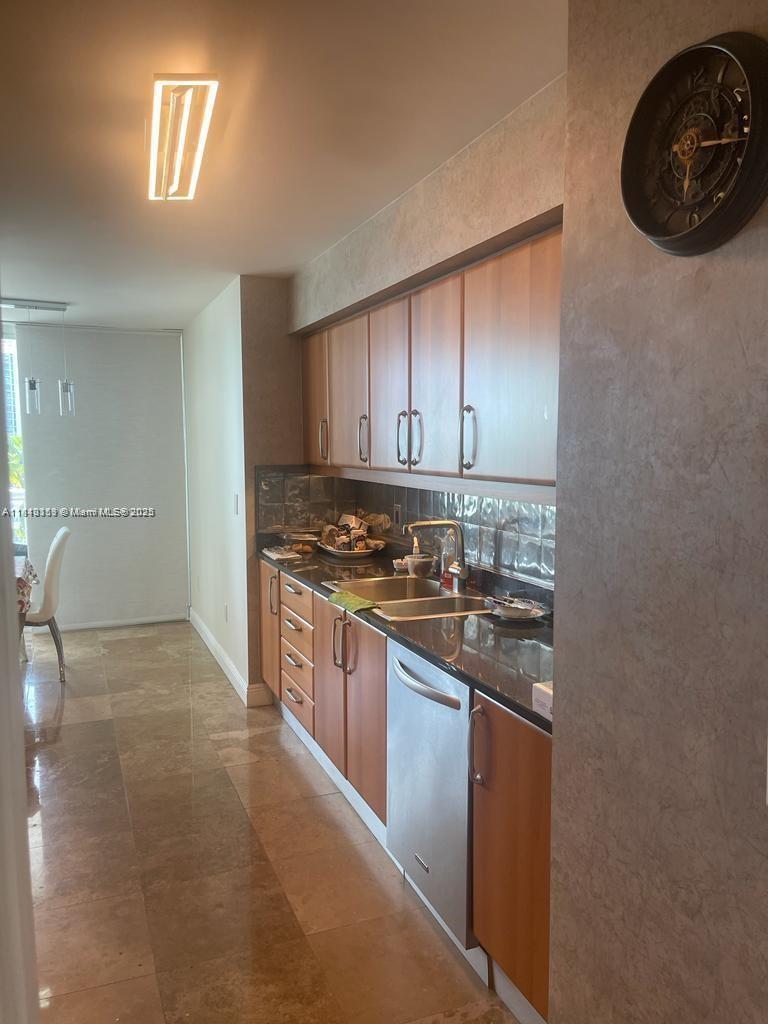 16500 Collins Avenue, Unit 652 Sunny Isles Beach, FL 33160 - Photo 3 of 6 a kitchen with stainless steel appliances granite countertop a stove a sink and a refrigerator with wooden floor