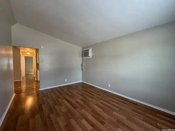 a view of empty room with wooden floor