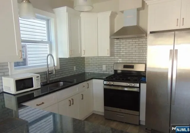 a kitchen with stainless steel appliances white cabinets and a stove