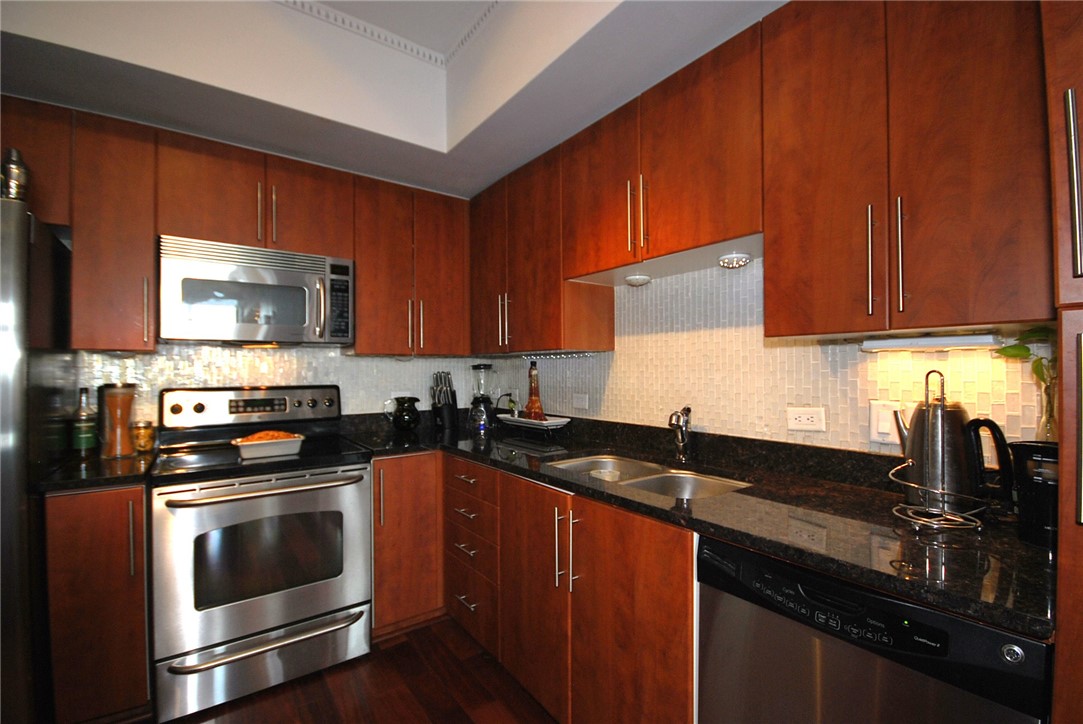 54 Rainey Street, Unit 509 Austin, TX 78701 - Photo 12 of 33 a kitchen with granite countertop a sink stove and microwave