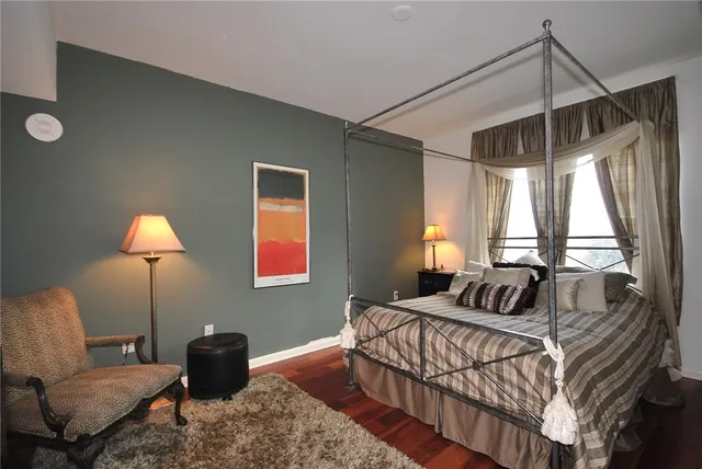 a bedroom with a bed a lamp and a large window