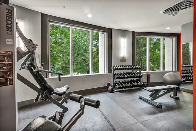 a living room with furniture gym equipment and a large window