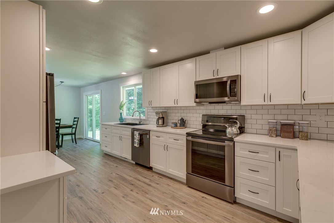 16623 Three Lakes Road Snohomish, WA 98290 - Photo 11 of 36 a kitchen with a stove top oven sink and cabinets