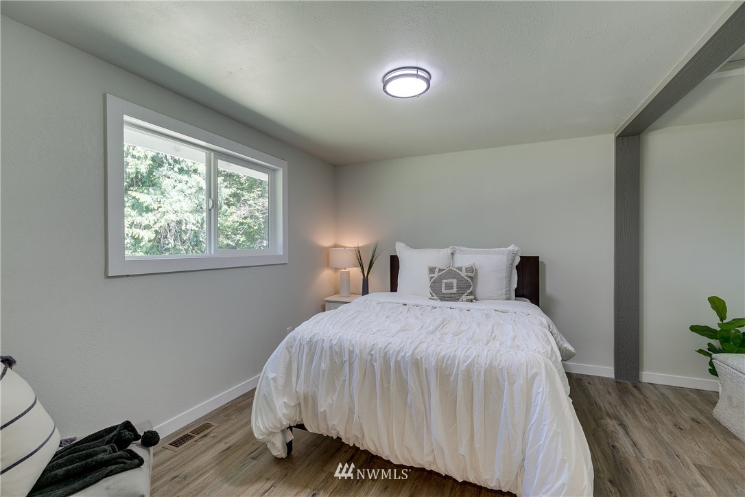 16623 Three Lakes Road Snohomish, WA 98290 - Photo 15 of 36 a bedroom with a bed and wooden floor
