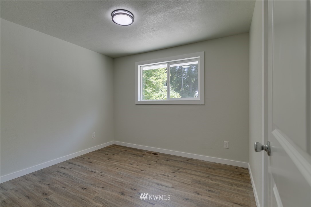 16623 Three Lakes Road Snohomish, WA 98290 - Photo 20 of 36 an empty room with wooden floor and windows