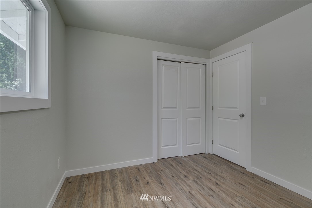 16623 Three Lakes Road Snohomish, WA 98290 - Photo 21 of 36 a view of an empty room with wooden floor and a window