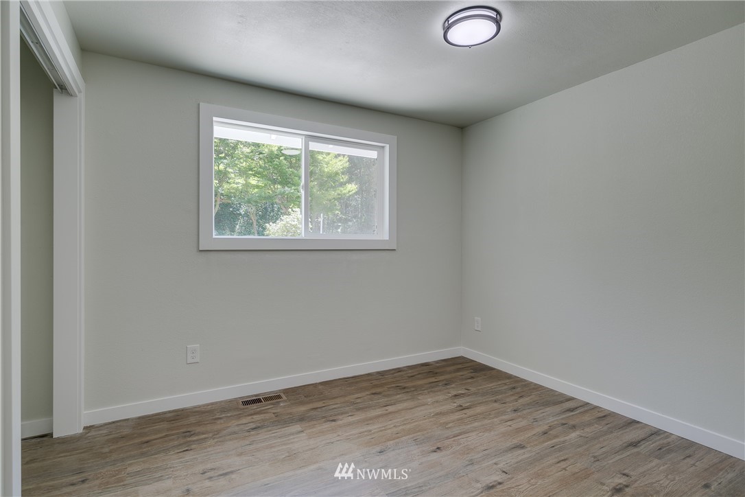 16623 Three Lakes Road Snohomish, WA 98290 - Photo 22 of 36 an empty room with wooden floor and windows