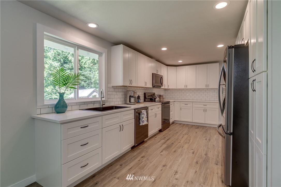 16623 Three Lakes Road Snohomish, WA 98290 - Photo 10 of 36 a kitchen with white cabinets and white appliances