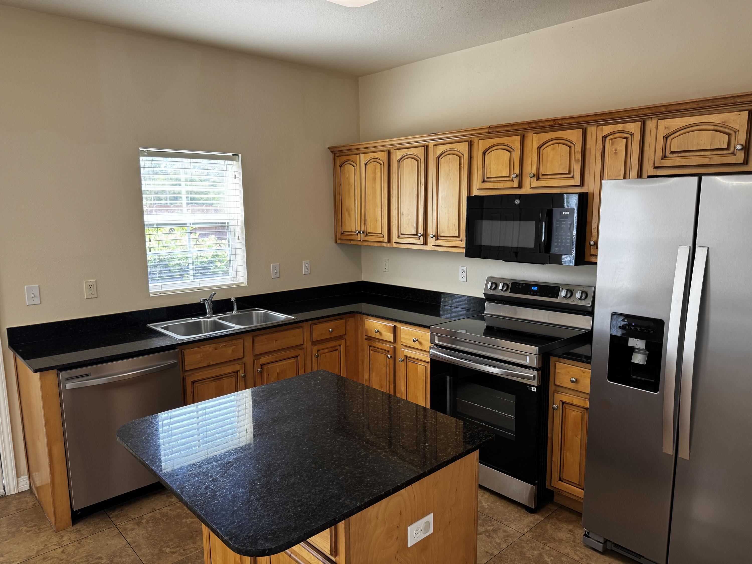 1512 Bentley Circle Fort Walton Beach, FL 32547 - Photo 5 of 12 a kitchen with granite countertop a refrigerator stove and microwave