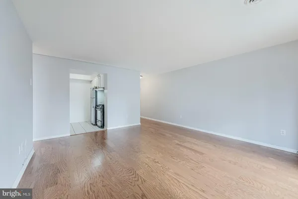 a view of an empty room with wooden floor