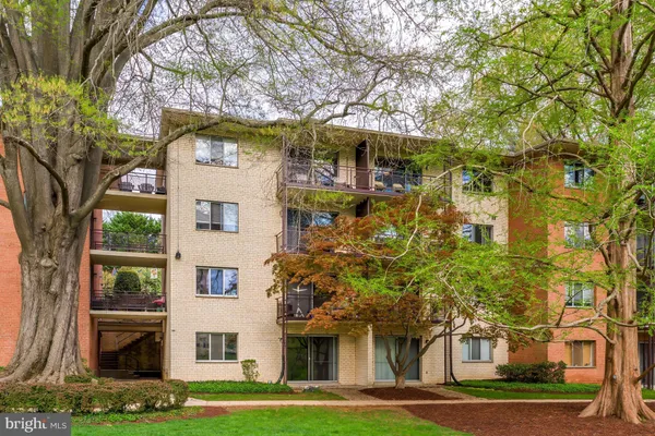 a front view of a residential apartment building with a yard