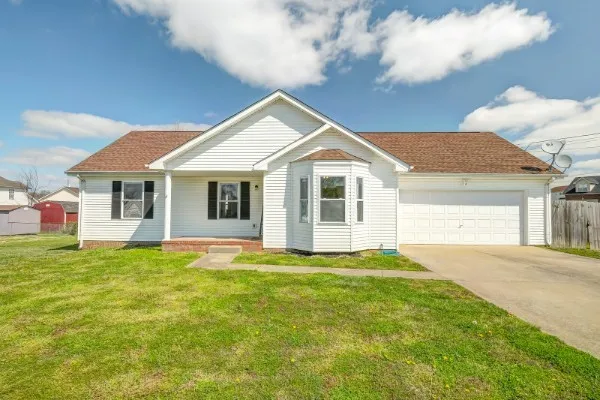 a front view of a house with a garden and yard