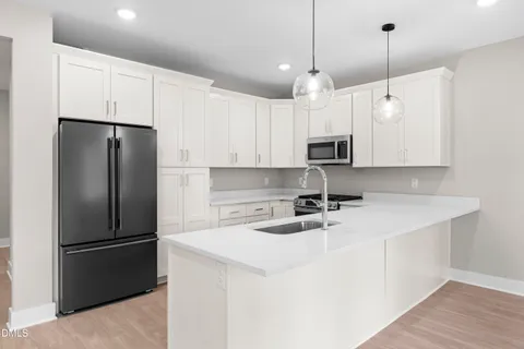 a kitchen with kitchen island a white cabinets and refrigerator