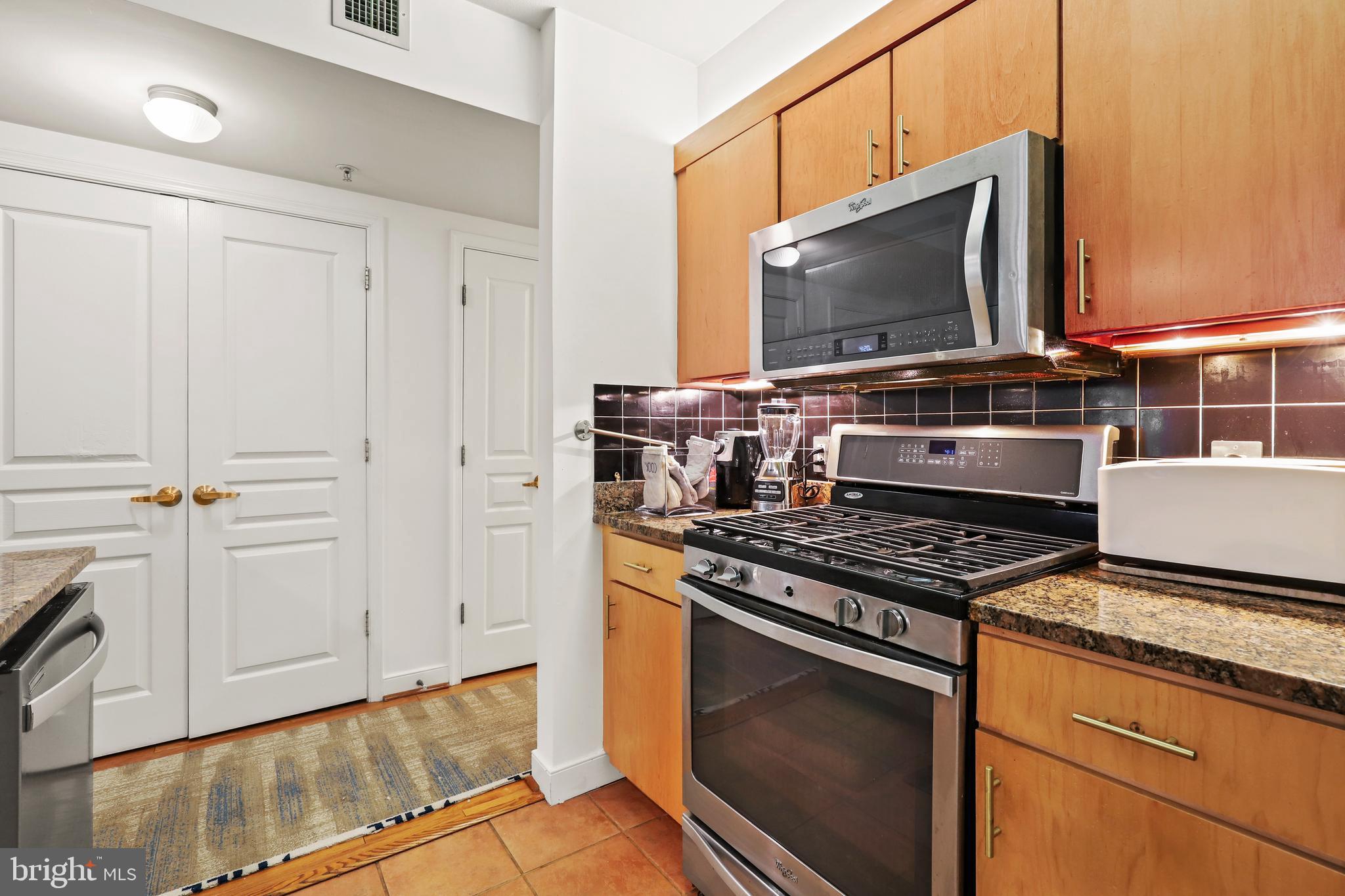 616 E Street Northwest, Unit 1007 Washington, DC 20004 - Photo 3 of 67 a kitchen with a stove and a microwave