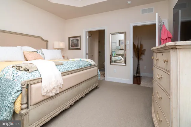 a bedroom with a bed dresser and mirror