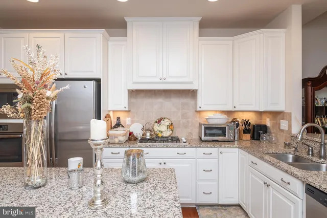 a kitchen with stainless steel appliances granite countertop a sink and cabinets