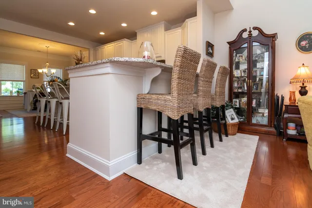 a kitchen with stainless steel appliances granite countertop table chairs and a living room