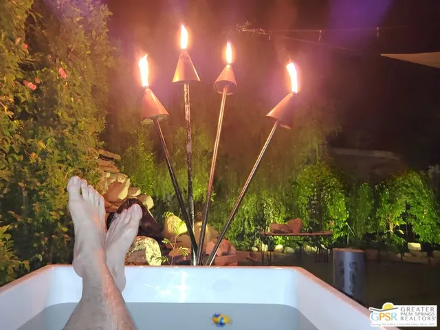 a view of a backyard with table and chairs under an umbrella