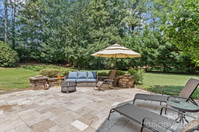 a view of backyard with outdoor seating barbeque oven and trees
