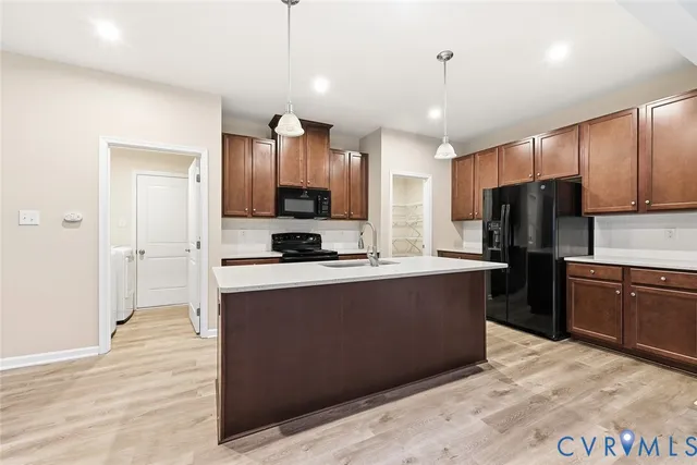 a large kitchen with kitchen island a sink stainless steel appliances and cabinets